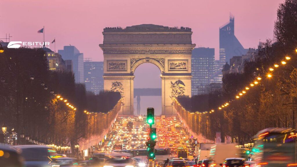 Arco di Trionfo illuminato sugli Champs Élysées al tramonto, Viaggio organizzato Capodanno a Parigi
