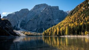 Lago di Braies con montagne e larici dorati riflessi nell’acqua, Viaggio organizzato Foliage al Lago di Braies