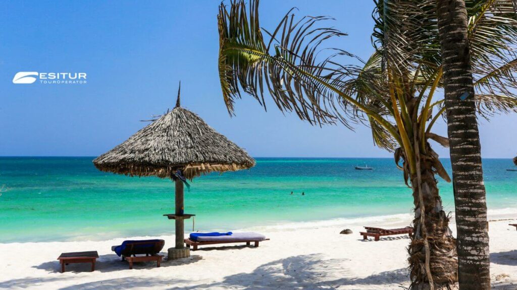 Spiaggia tropicale con palme, mare turchese e lettini sulla sabbia, Quando andare in Kenya per una vacanza al mare