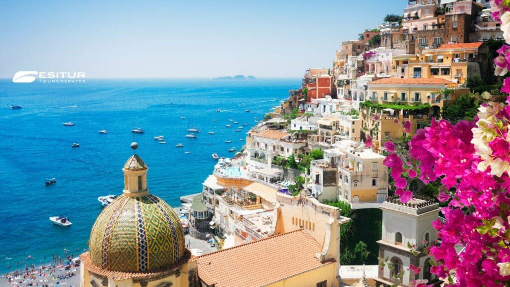 Veduta di Positano con case colorate e cupola sul mare, tra i Paesi più belli della Costiera Amalfitana per un viaggio nel Sud Italia