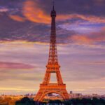 Torre Eiffel al tramonto sotto un cielo colorato, viaggio Capodanno a Parigi da Milano per scoprire la capitale francese.