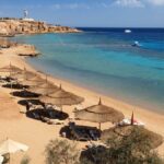 Spiaggia con ombrelloni affacciata sul Mar Rosso, Viaggio Capodanno a Sharm el-Sheikh da Milano.